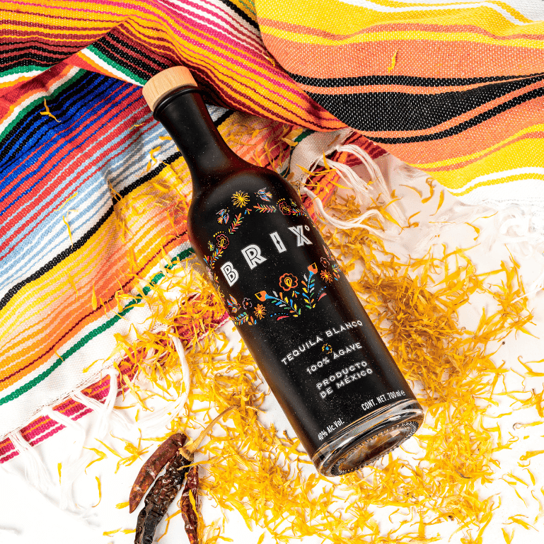 una botella de BRIX Tequila con decoración mexicana