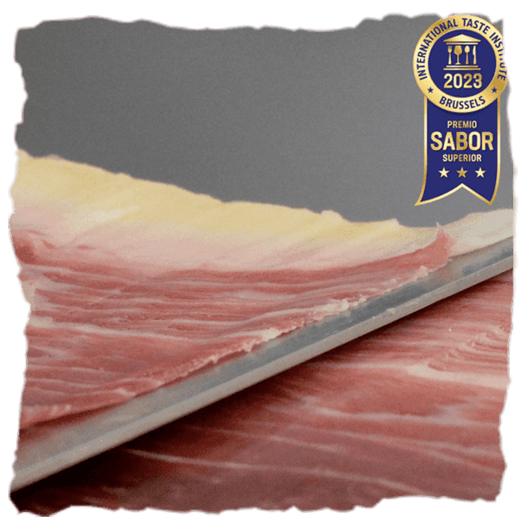 un cuchillo corta un jamón ibérico