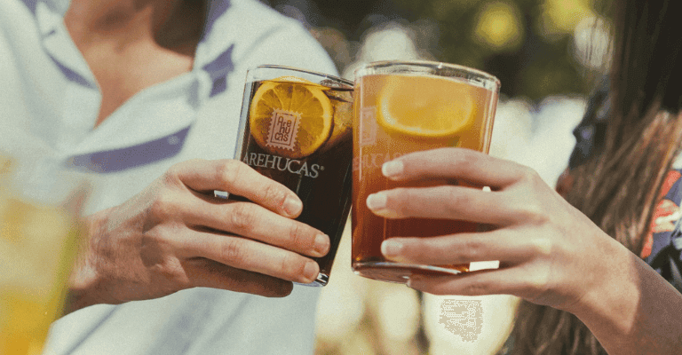 manos sostienen vasos de ron Arehucas