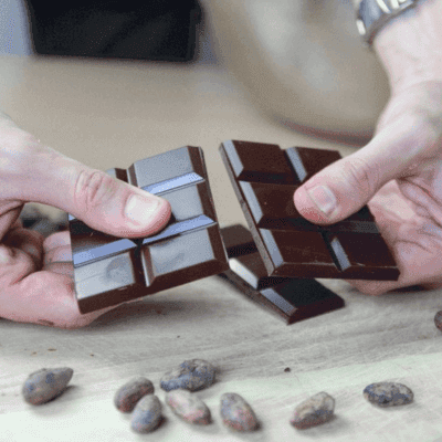 manos sostienen una tableta de chocolate