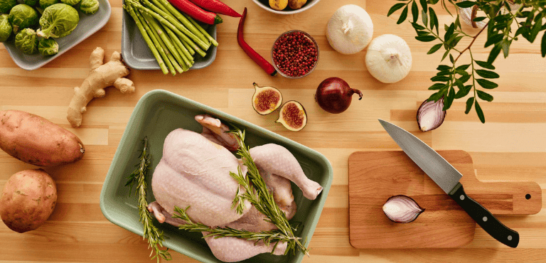 pollo entero y otros ingredientes sobre una mesa
