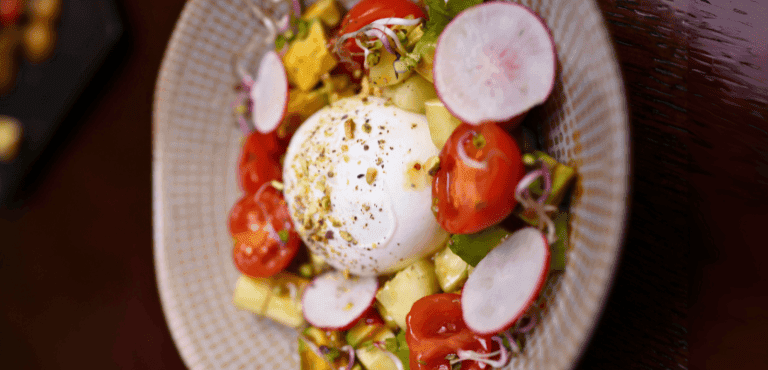 un plato de ensalada con queso burrata