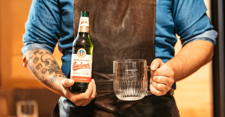 hombre sostiene cerveza Budvar