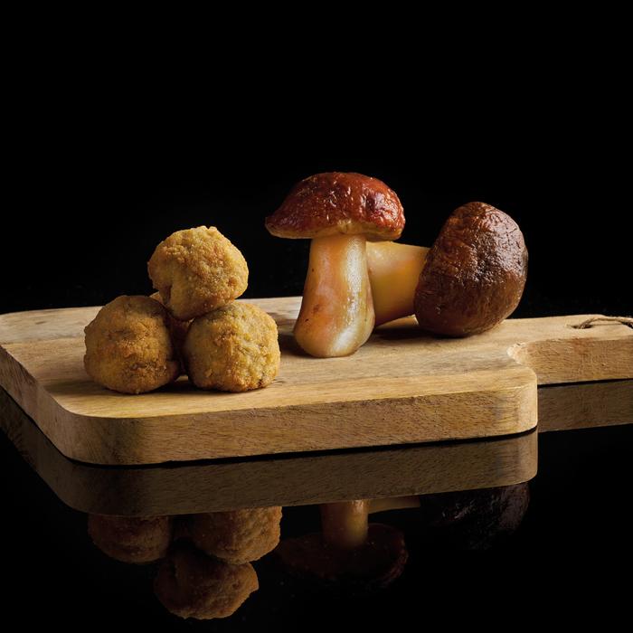 tabla de madera con croquetas de boletos y una boletus