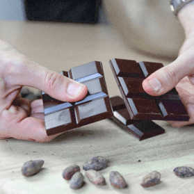 manos cortando chocolate negro de essenzo cacao