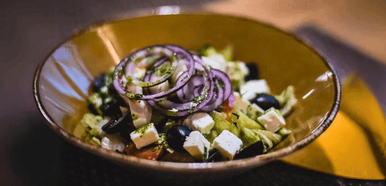 un bol de ensalada con varios vegetalescy queso