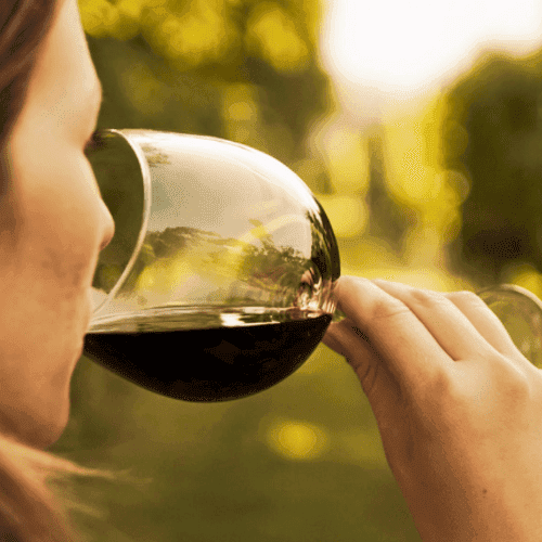 una mujer bebiendo una copa con vino