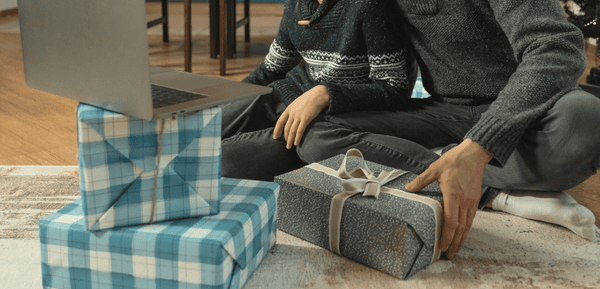 Padre e hijos con unas cajas de regalo para celebrar el Día del Padre con regalos originales que se pueden comprar online