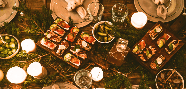 una mesa navideña con copas, platos y aperitivos originales para Navidad que son fáciles de hacer y muy sabrosos, ideales para acompañar con una cerveza