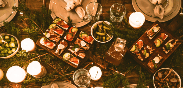 una mesa navideña con copas, platos y aperitivos originales para Navidad que son fáciles de hacer y muy sabrosos, ideales para acompañar con una cerveza