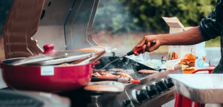 Una persona prepara una barbacoa al aire libre con aperitivos deliciosos.