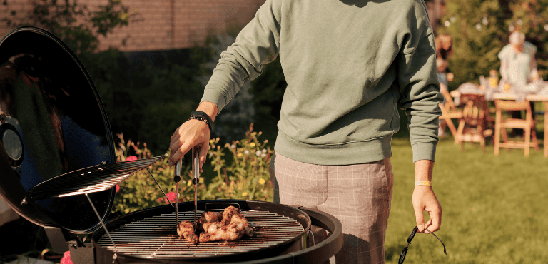Un hombre prepara una barbacoa al aire libre con carne de alta calidad.