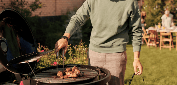 Un hombre prepara una barbacoa al aire libre con carne de alta calidad.