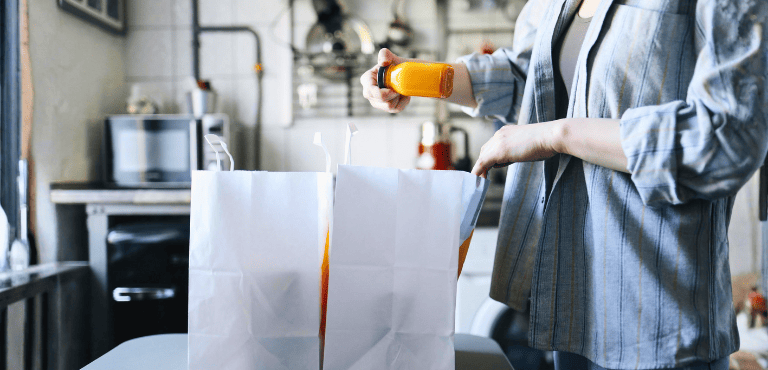 Una persona saca de las bolsas los productos que compró online con las ofertas de Black Friday para llenar su despensa siguiendo estos consejos