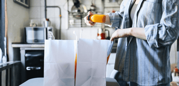 Una persona saca de las bolsas los productos que compró online con las ofertas de Black Friday para llenar su despensa siguiendo estos consejos