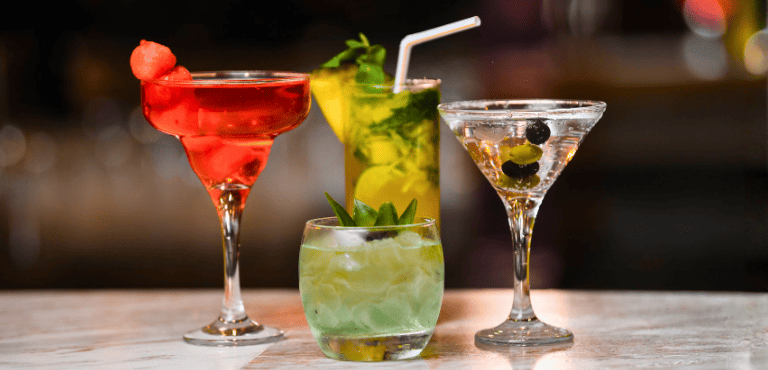 Varias copas con cócteles con ginebra, recetas clásicas y deliciosas para beber.
