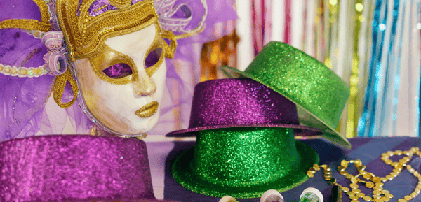Una máscara, gorros coloridos y decoración para organizar una fiesta de Carnaval en casa con cerveza y buen rollo