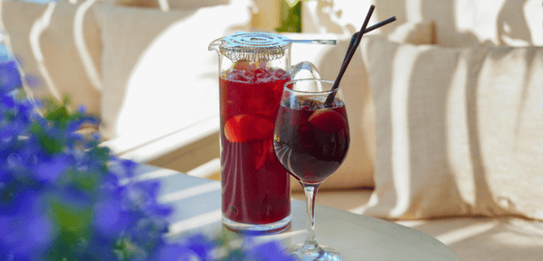Una jarra y copa con tinto de verano, la bebida deliciosa y refrescante hecha de forma casera con vino tinto.