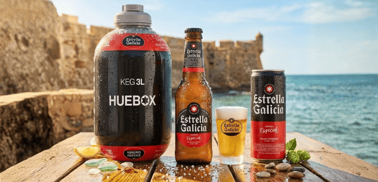 Diferentes formato de cervezas Estrella Galicia en botella, lata, barril para Huebox y vaso de cerveza sobre una mesa con un fondo de playa.