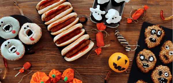 Una mesa llena de comida y aperitivos para celebrar Halloween de forma creativas con ideas deliciosas y llamativas en forma de fantasmas, monstruos, calaveras y momias.