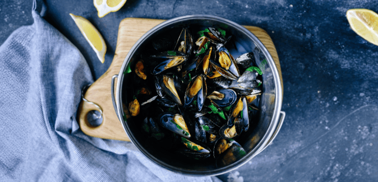 Una olla con mejillones al vino blanco preparados con la receta francesa, un plato delicioso y tradicional que resulta muy fácil de preparar en pocos minutos, ideal para mojar pan.