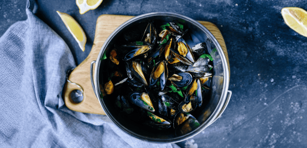 Una olla con mejillones al vino blanco preparados con la receta francesa, un plato delicioso y tradicional que resulta muy fácil de preparar en pocos minutos, ideal para mojar pan.