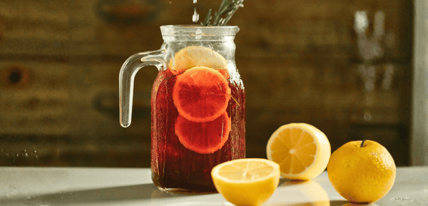 Una jarra con la receta de limonada de vino y limones, un clásico de los tardeos que combina la potencia del tinto con el toque cítrico del limón y la naranja para crear una bebida ligera, original y deliciosa.