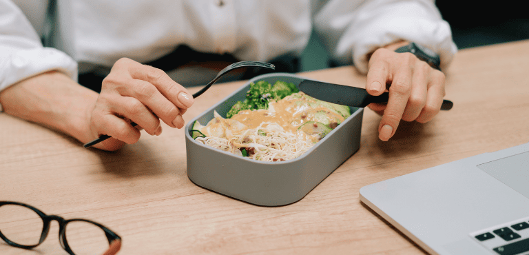 Una persona corporativa como su tupper con comida para el trabajo, hecha con una receta fácil y rápida.