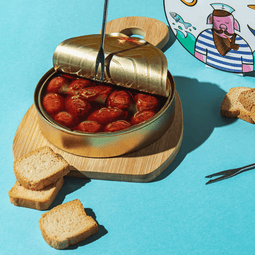Una lata abierta de conserva A Casa Da Avoa, una preparación cárnica auténtica, práctica y llena de sabor sobre una tabla.