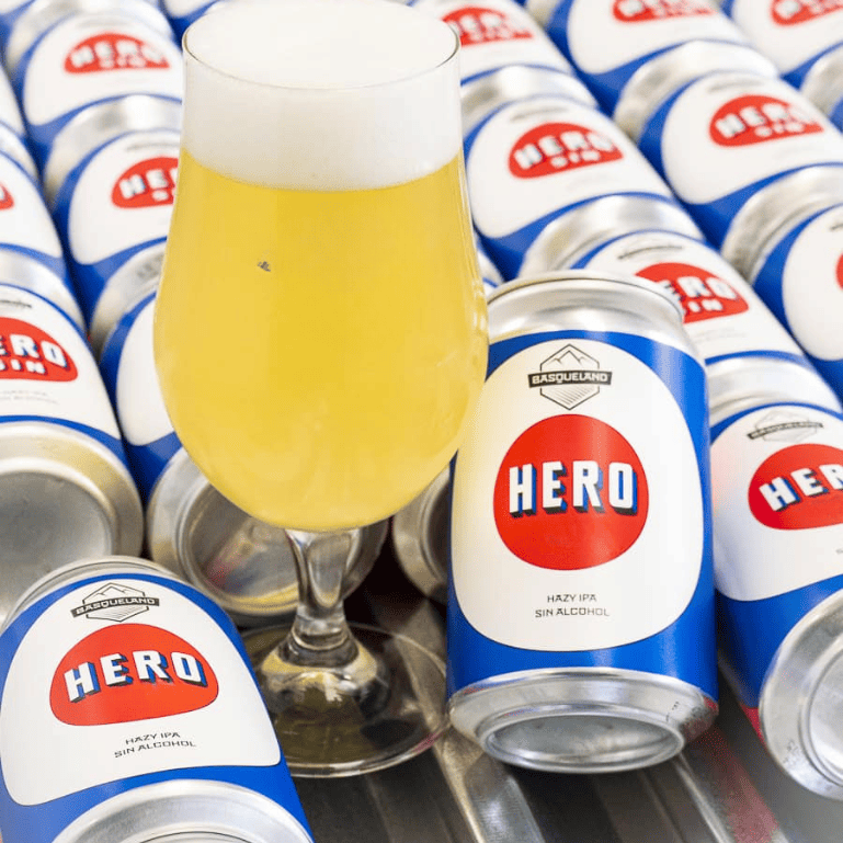 Una botella de Basqueland Hero Hazy IPA 0.5 %, sin alcohol, aromática con mango, fruta de hueso y cítricos; refrescante y cargada de lúpulo en un estilo hazy puro