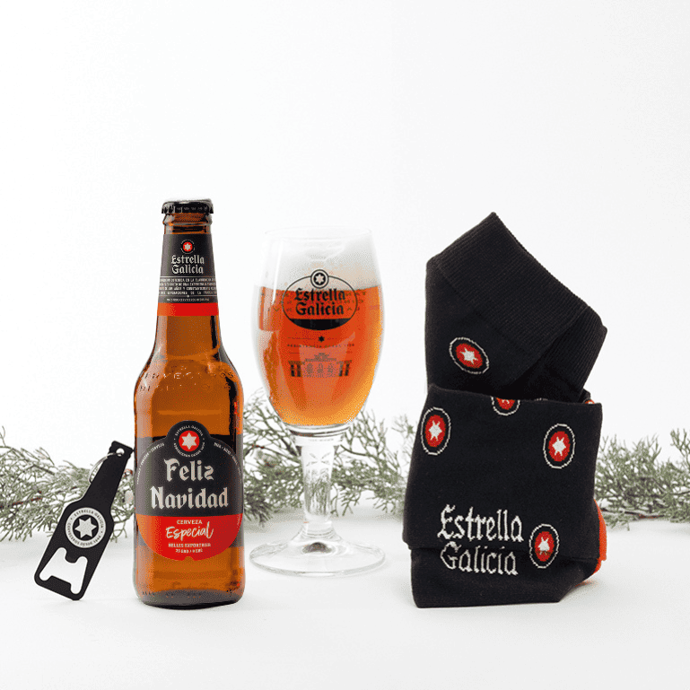 Un pack Amigo Invisible de Estrella Galicia, que incluye un estuche de cerveza Estrella Galicia edición Feliz Navidad, un par de calcetines negros y llavero negro, siendo un regalo perfecto para compartir durante estas fechas y sorprender a esa persona especial