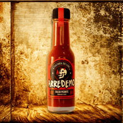 una botella de Salsa Arredemo de Factoría do Lume de 100 ml, fermentada con chiles jalapeños y Bhut Jolokia, ofrece un picante intenso que se revela tras un breve fantasma de sabor