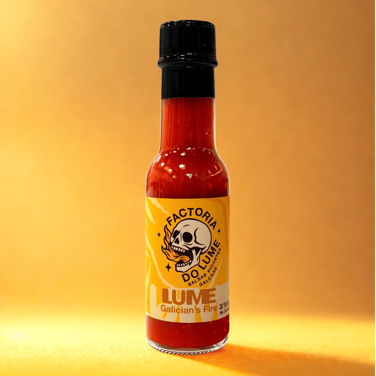 una botella de 100 ml de Salsa Lume de Factoría do Lume, una salsa picante artesanal de jalapeños y ajo asado, perfecta para realzar sabores en diversos platos.