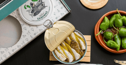 Una lata de sardinas en AOVE con pimientos de Padrón de La Curiosa, son sardinas premium en aceite extra virgen y pimientos de padrón, todo hecho a mano en la Ría de Arousa