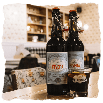 dos botellas de Vermut Rivera rojo, clásico con aromas de lúpulo cascade, pétalos de rosa y hierbas, aportando complejidad y un toque lupulado