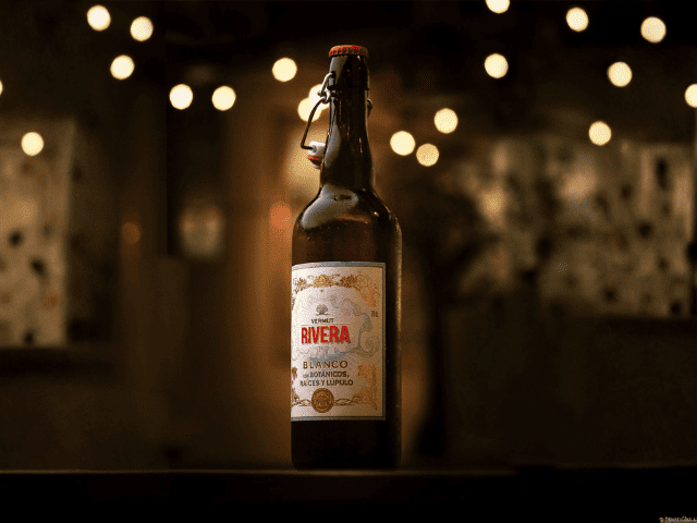 una botella de Vermut Rivera blanco, clásico elegante con lúpulo Nugget gallego, aroma herbacéo y notas de genciana, naranja y ruibarbo, sabor moderado‑amargo