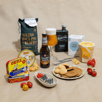 Un pack de cerveza Estrella Galicia 0,0, arroz, conservas, coctel, galletas y frutas para un maridaje delicioso.