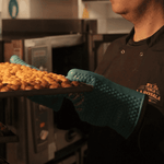 una persona saca una bandeja de frutos secos del horno para ponerlos a reposar a temperatura ambiente, permitiendo que los aromas se asienten de forma orgánica