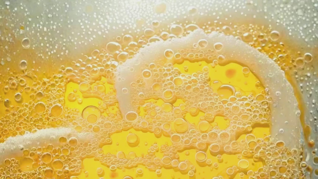 Espuma y líquido de una cerveza rubia con llamativa espuma blanca y burbujeo frecuente.