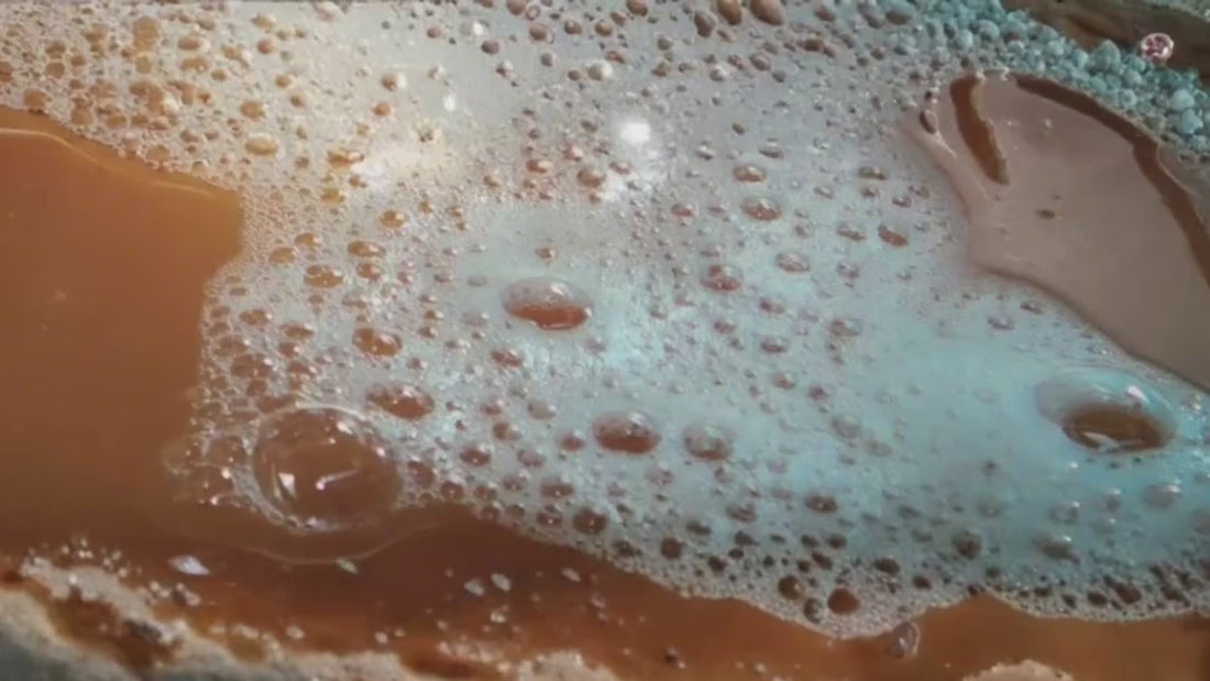 Proceso de hervido de una cerveza rubia en su elaboración, con espuma blanca y color llamativo en el líquido