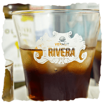 un vaso con Vermut Rivera rojo que combina lúpulo cascade, pétalos de rosa y hierbas en un clásico aromático y ligeramente lupulado